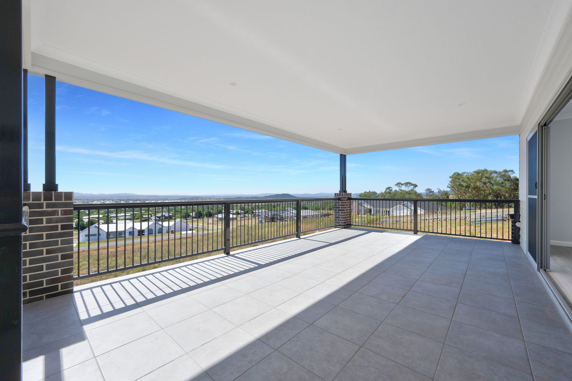 An empty balcony with a view of a city and trees