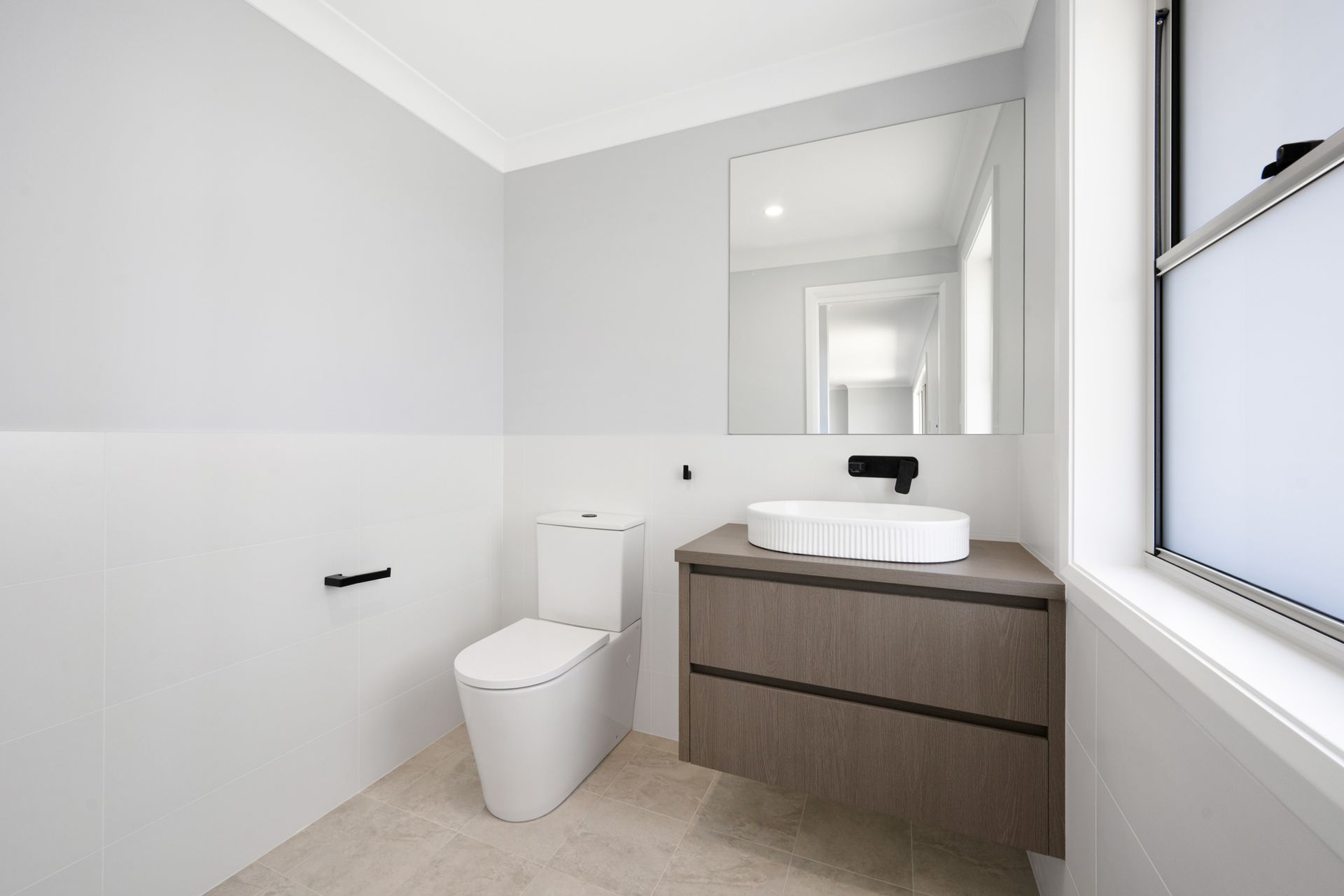 A bathroom with a toilet , sink and mirror