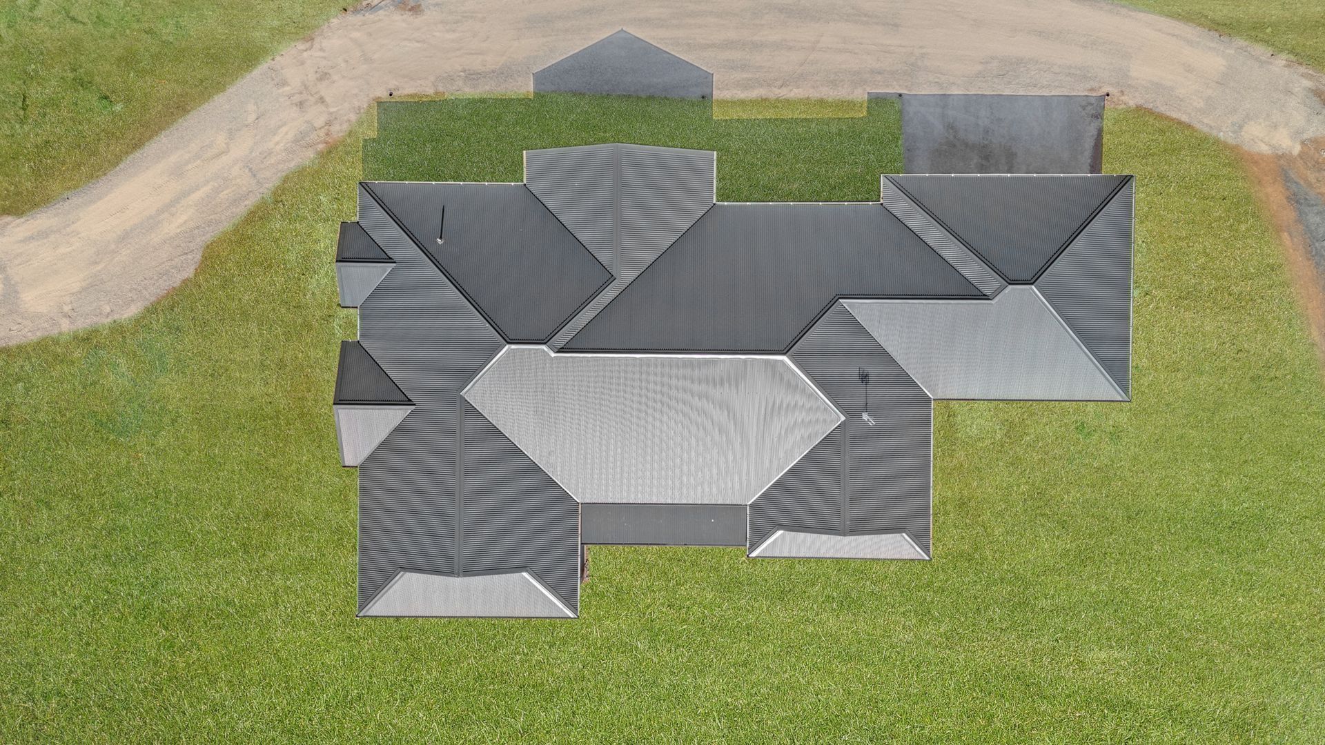 An aerial view of a house with a gray roof