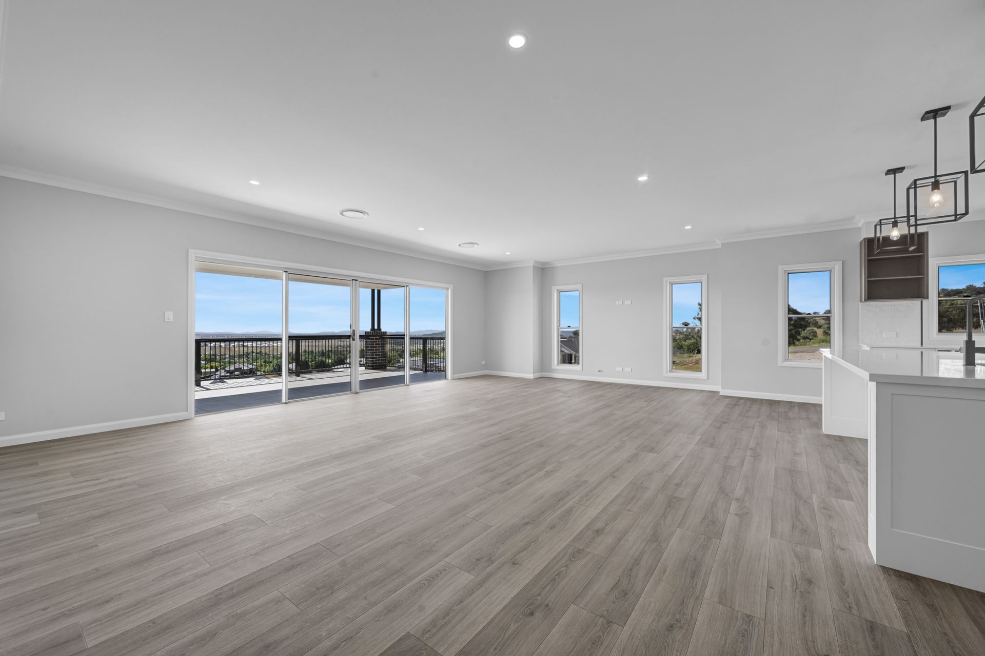 A large empty room with hardwood floors and lots of windows.