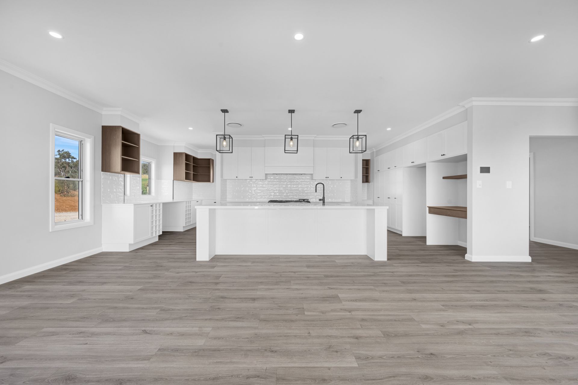 An empty kitchen with a large island in the middle of the room.