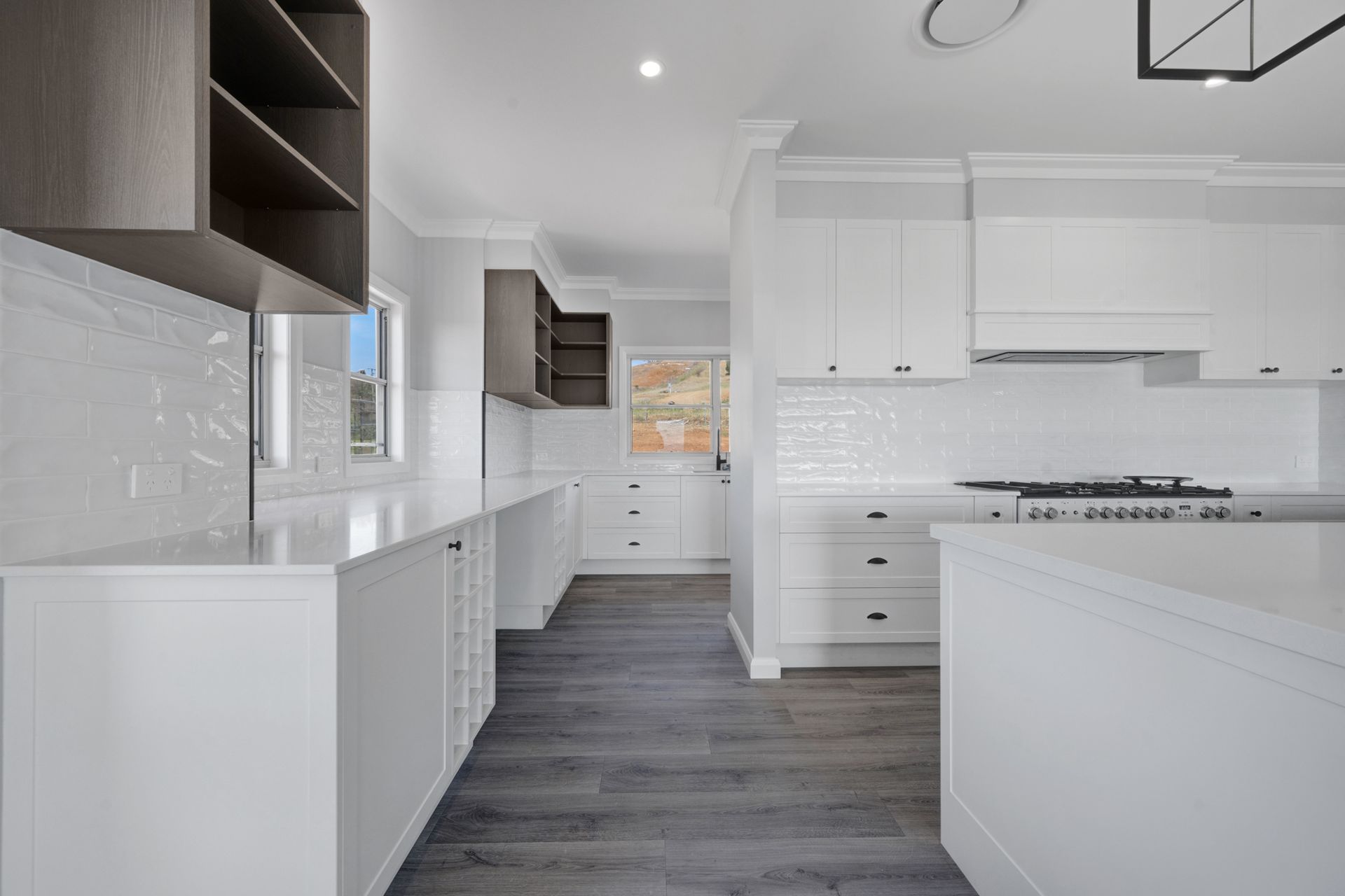 A kitchen with white cabinets and a stove top oven.