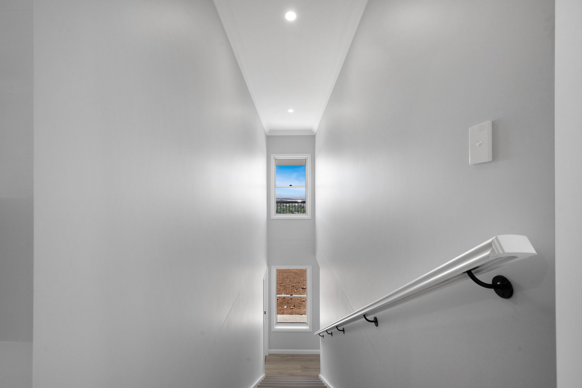 A long hallway with stairs leading up to the second floor of a house.