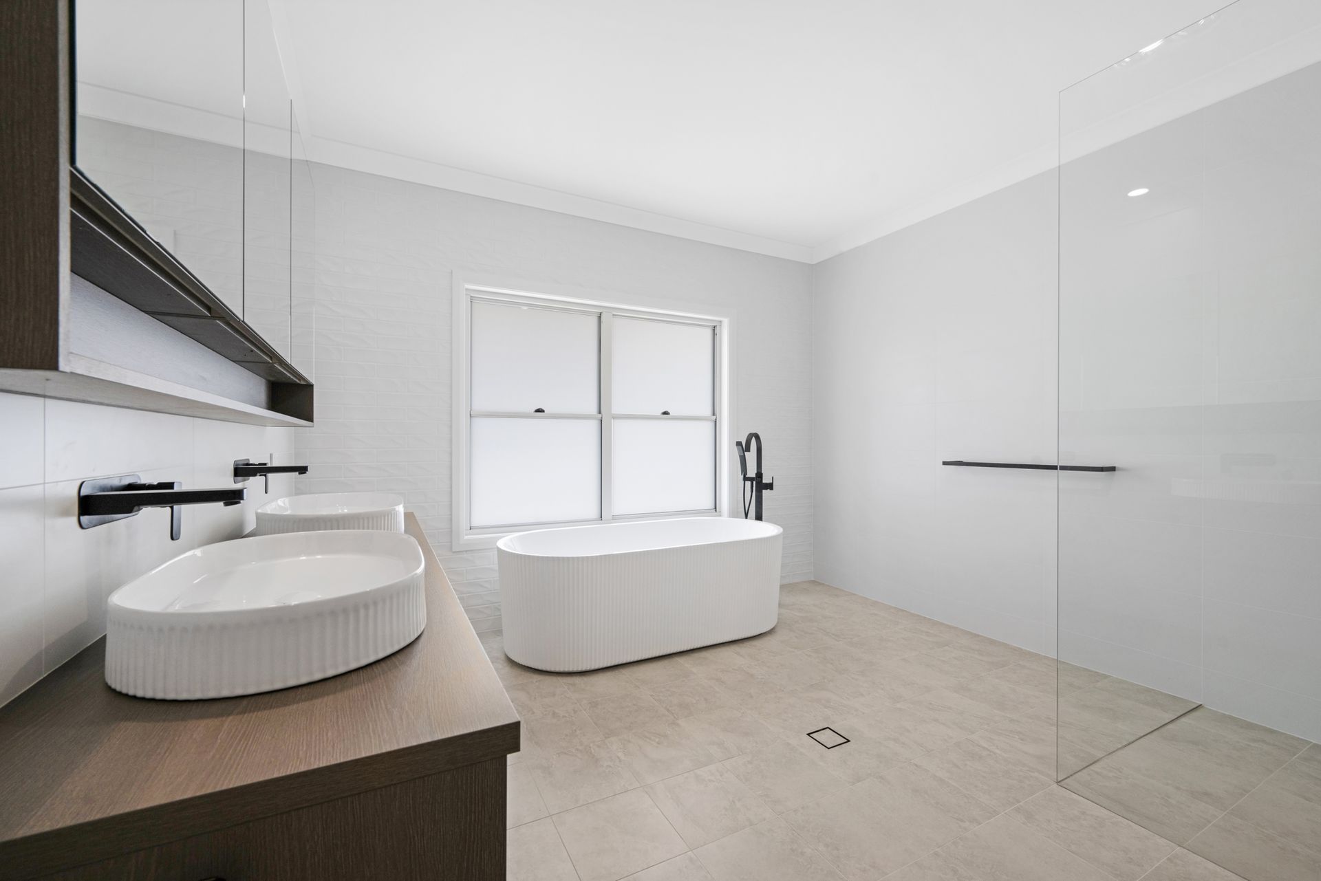 A bathroom with two sinks , a bathtub and a walk in shower.