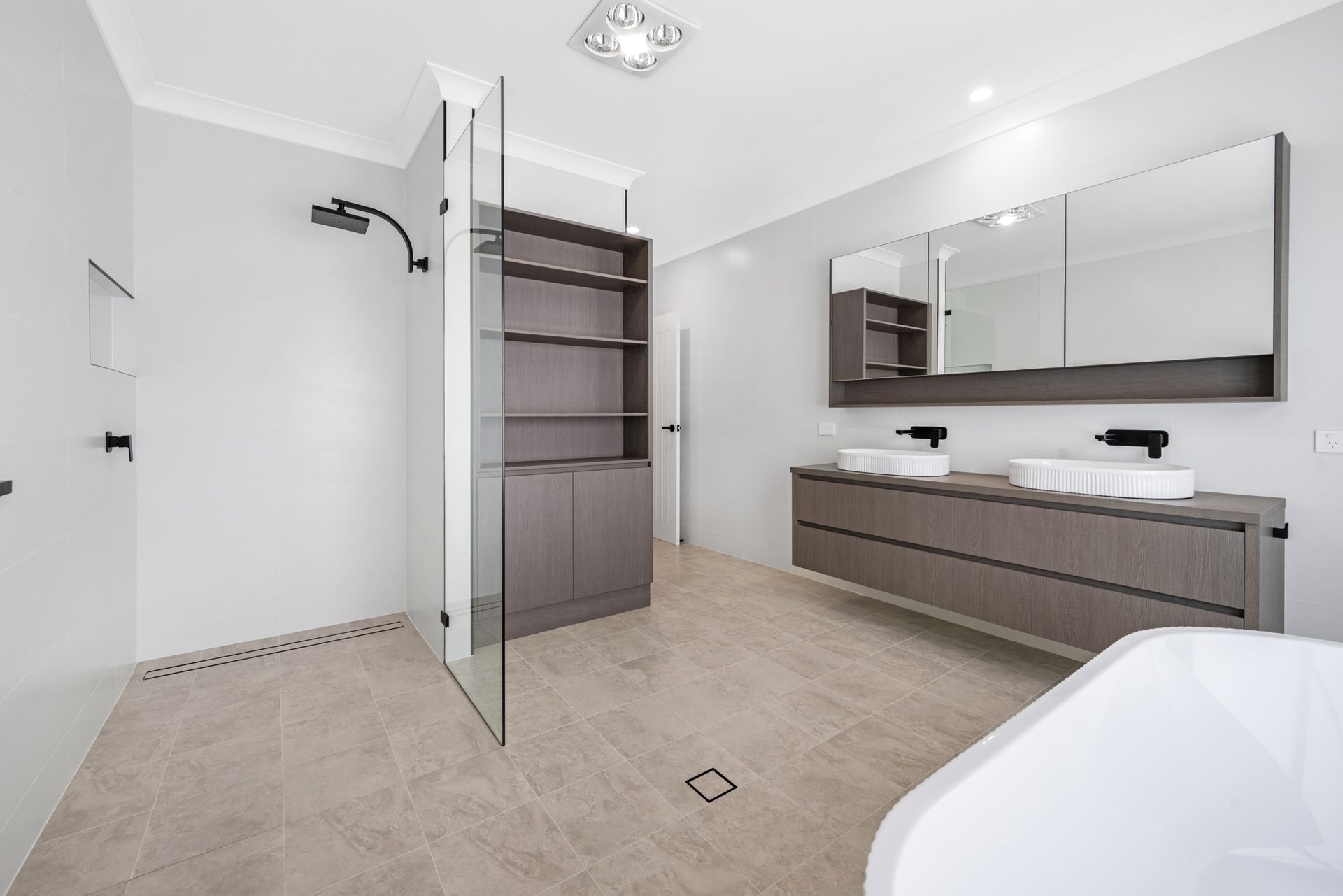 A bathroom with two sinks , a tub and a shower.