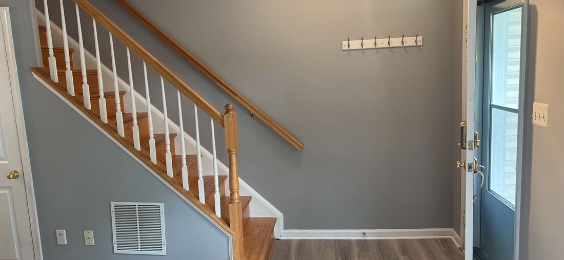 A hallway with stairs leading up to the second floor of a house.