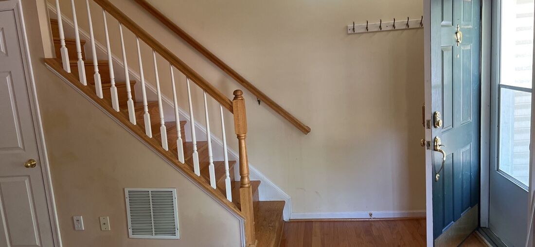 A hallway with stairs leading up to the second floor of a house.