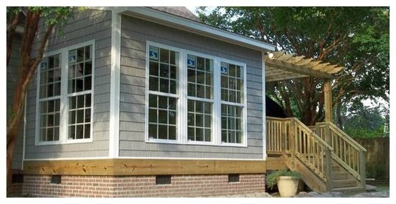 A house with a porch and stairs has a lot of windows