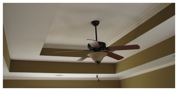 A ceiling fan is hanging from the ceiling of a room