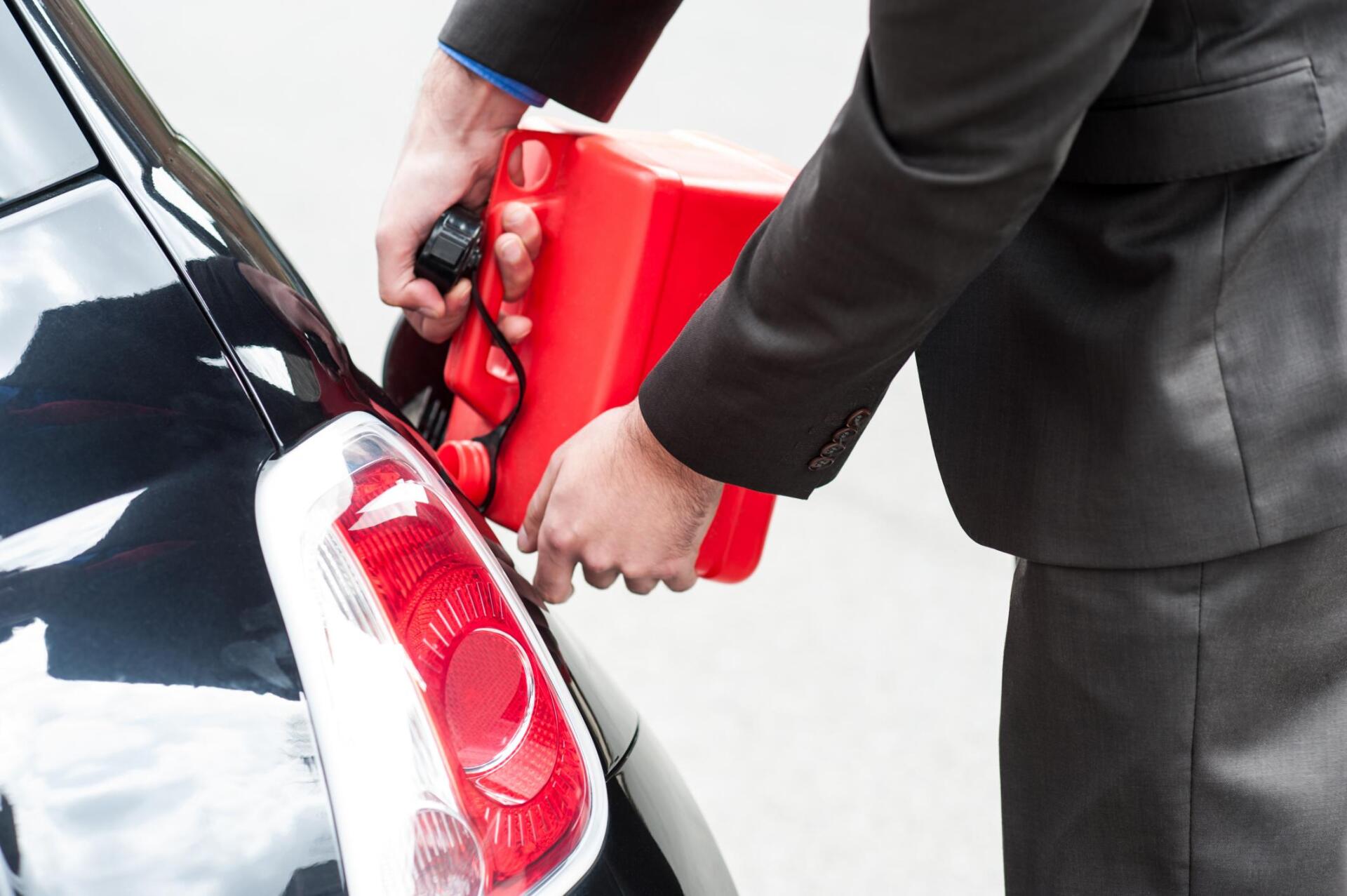 someone pouring the gas on the car tank