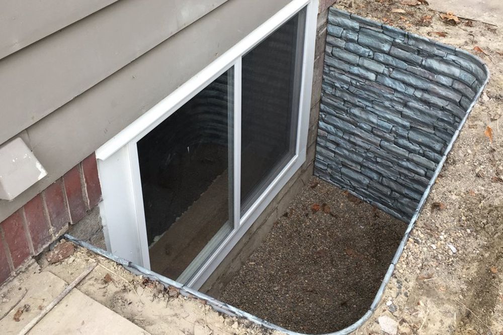 A window in a basement with a screen on it