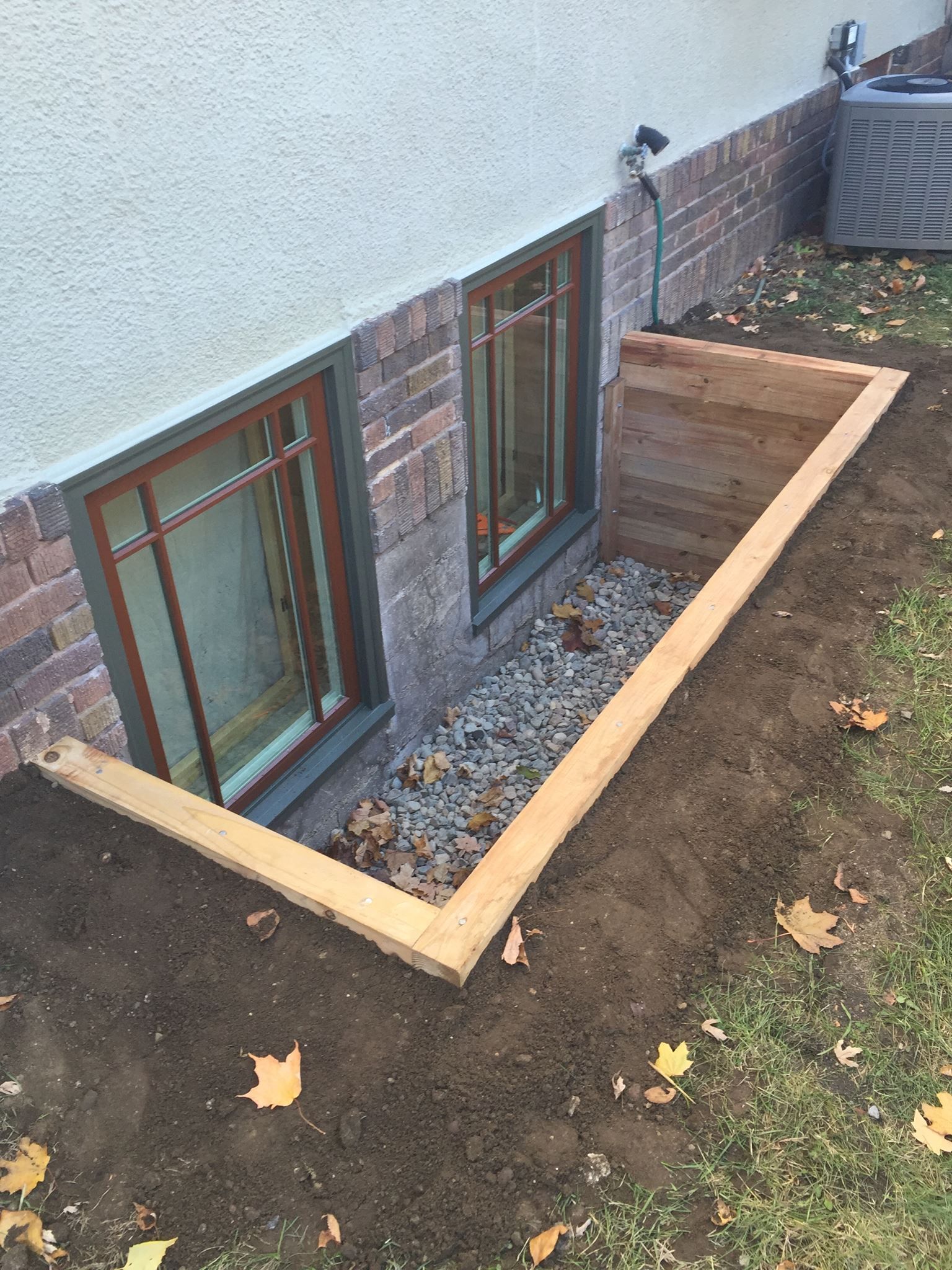 There is a window in the basement of a house.