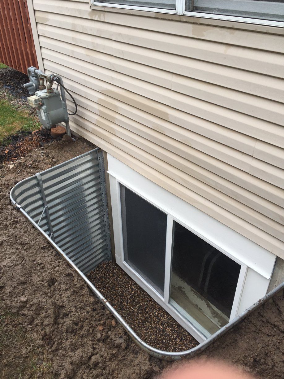 There is a window in the basement of a house.