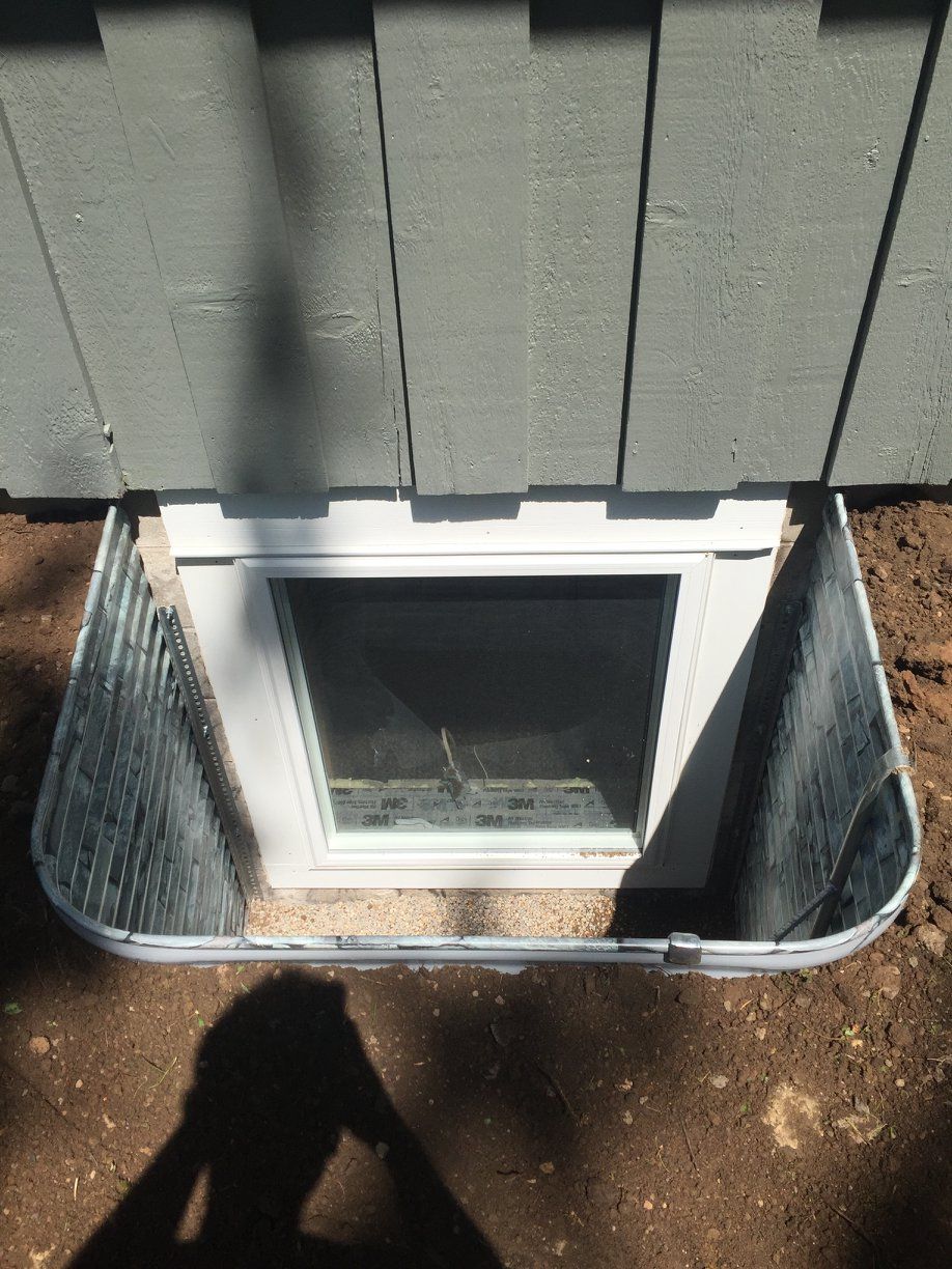 A window in the ground next to a house