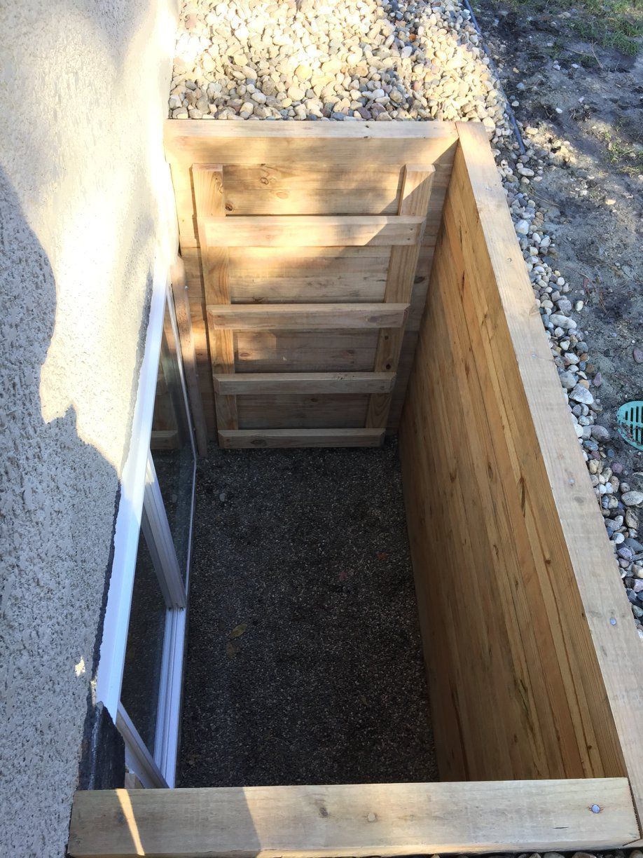 A wooden box is being built next to a window.