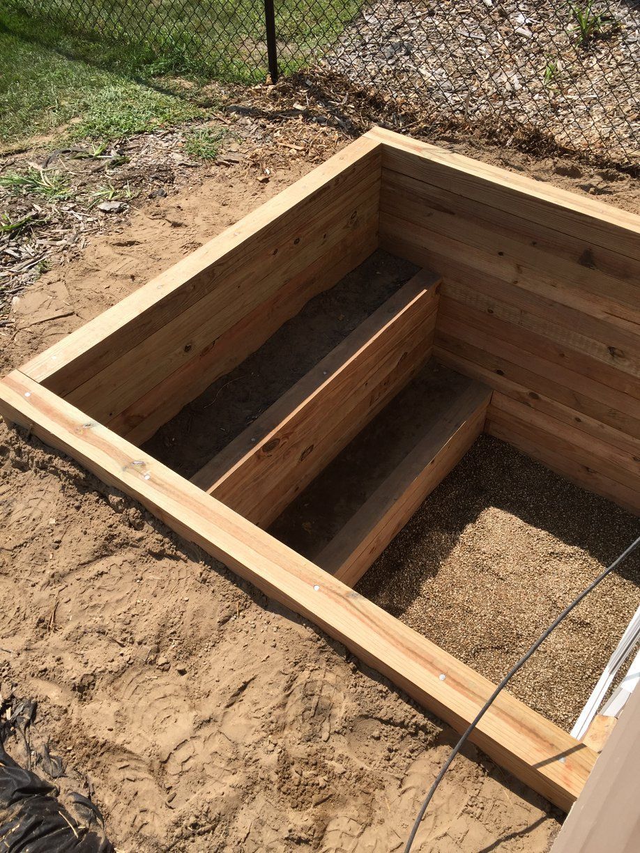 A wooden box is sitting on top of a pile of dirt.