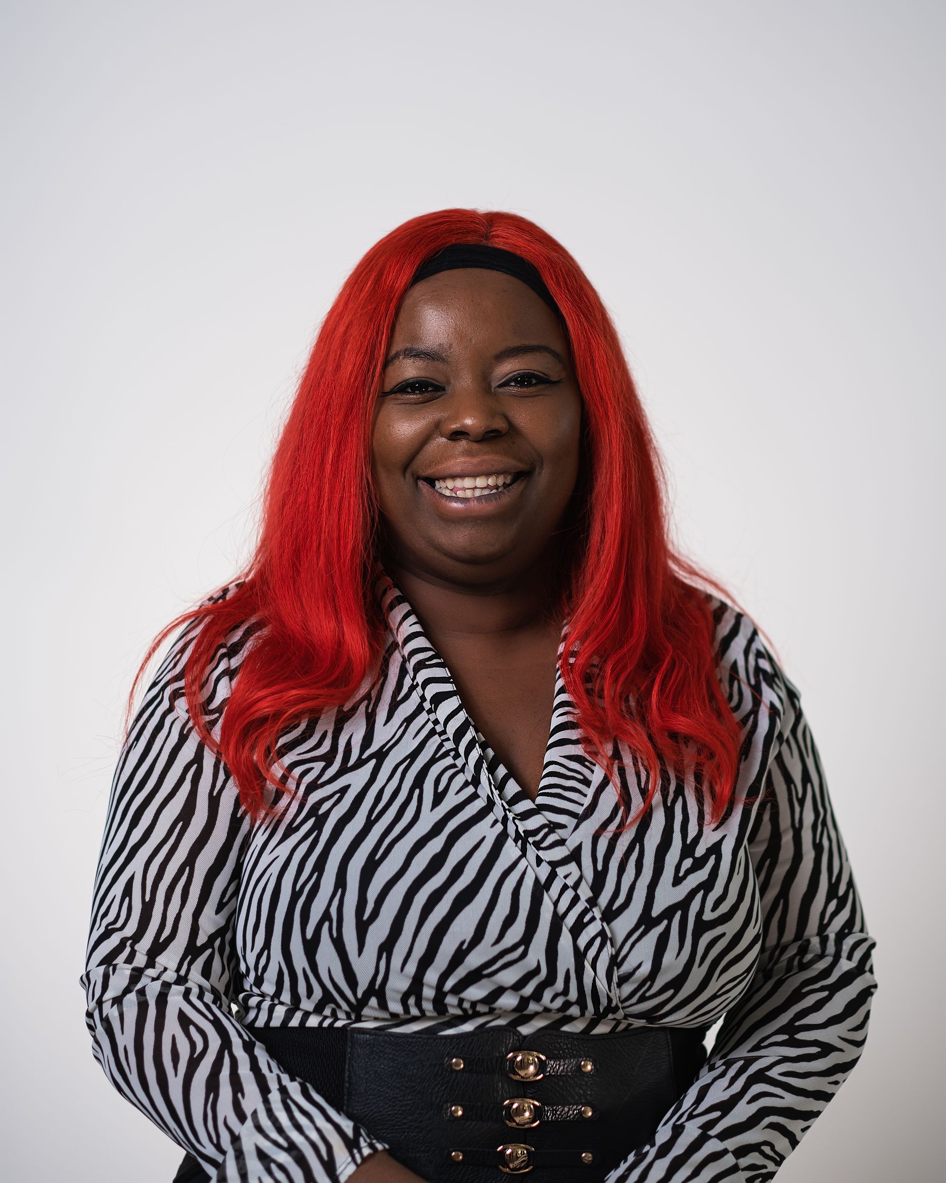 Une femme aux cheveux rouges porte une chemise à imprimé zèbre