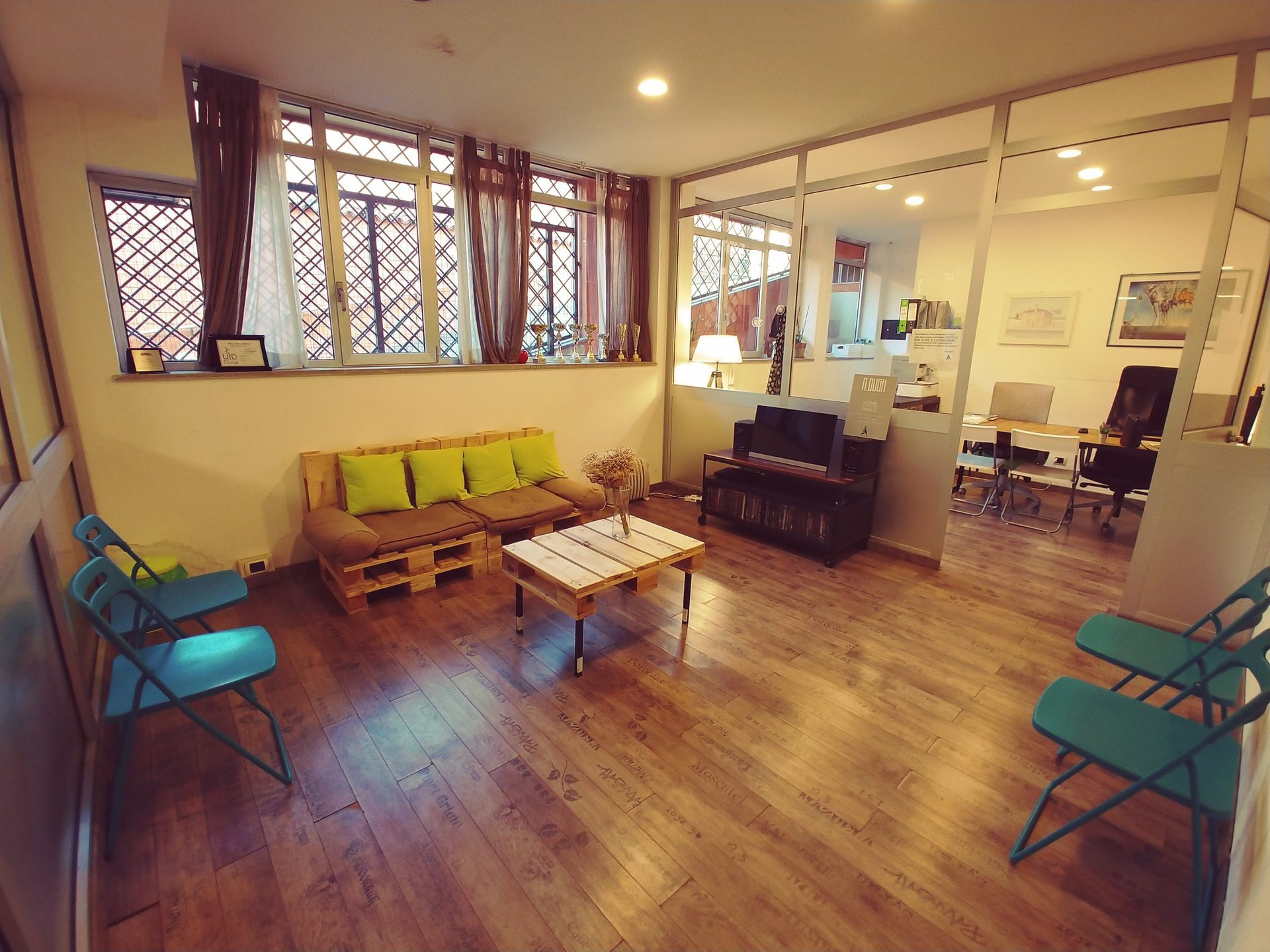 Accogliente sala d'attesa con pavimenti in legno chiaro, sedute e finestre.