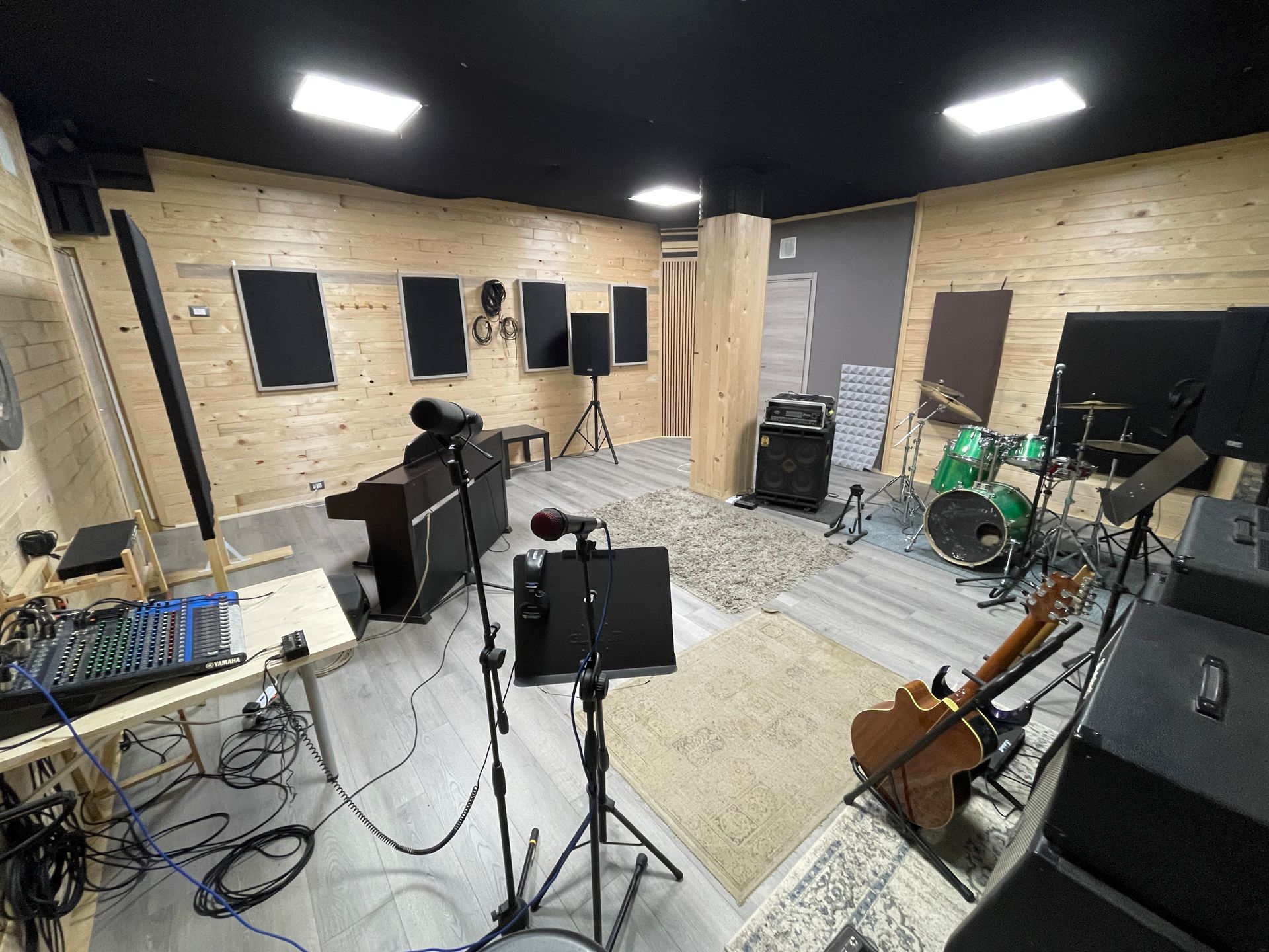 Studio di registrazione con strumenti, insonorizzazione e attrezzatura installata.