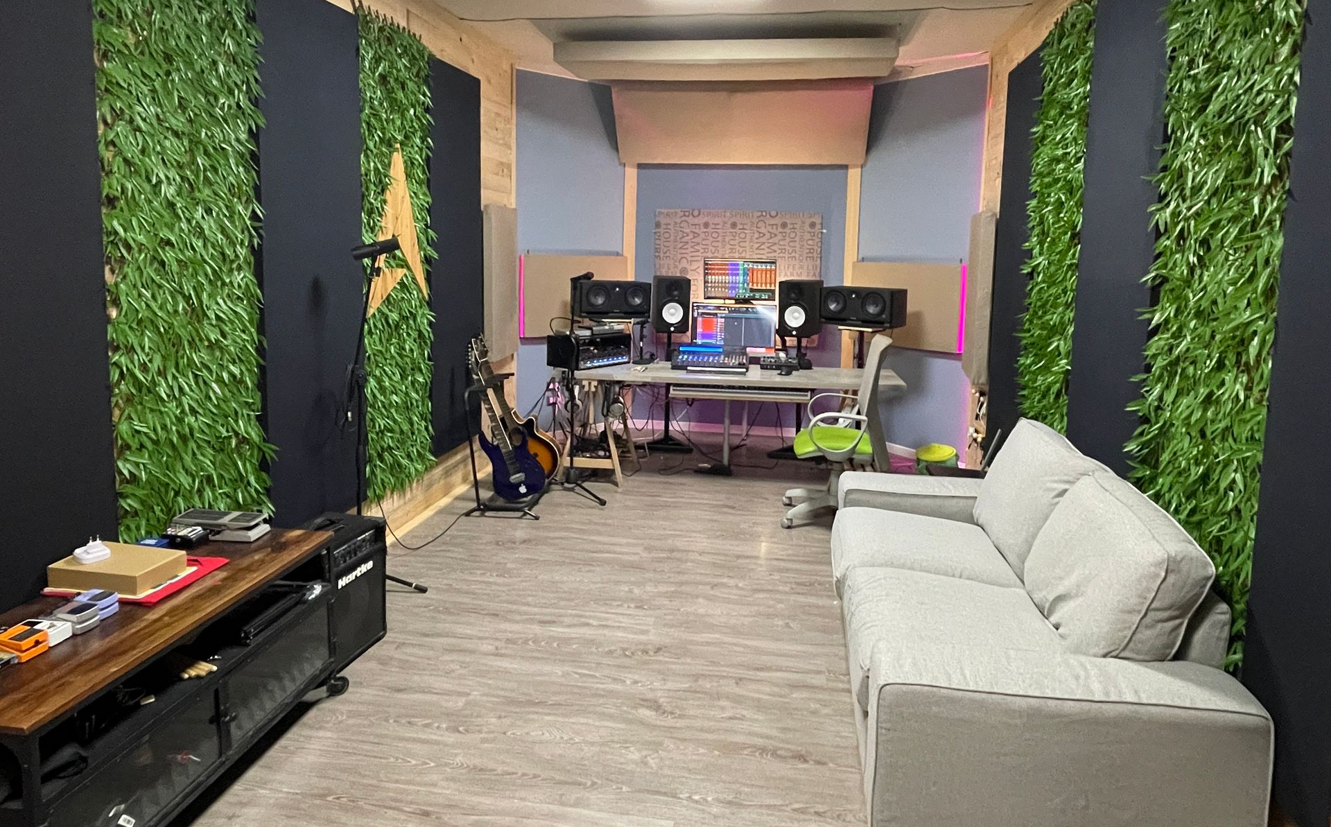 Pianoforte in studio di registrazione con batteria e altoparlanti. Pareti in legno.