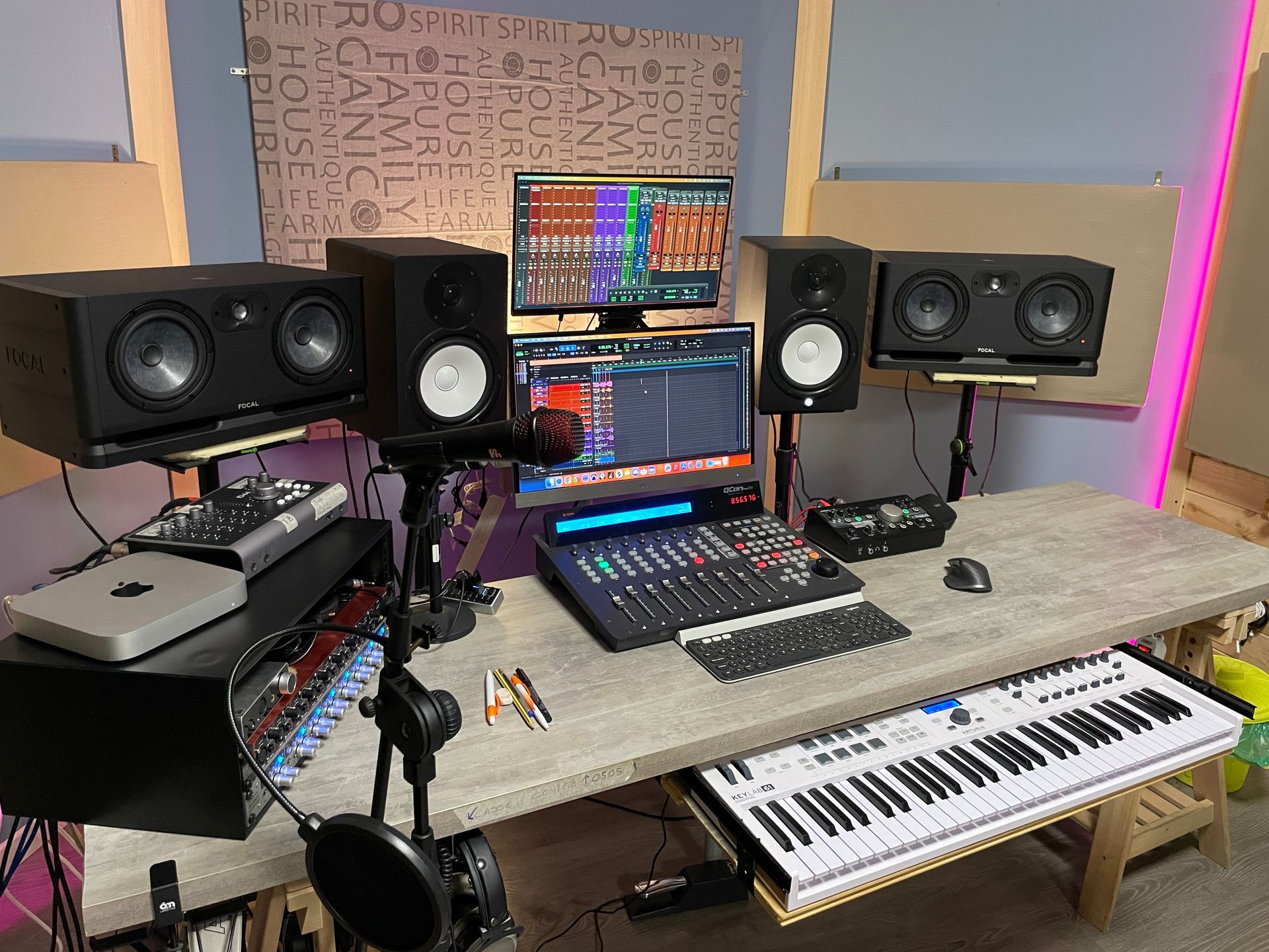 Postazione di lavoro in studio di registrazione con monitor, tastiera, mixer e varie apparecchiature audio.