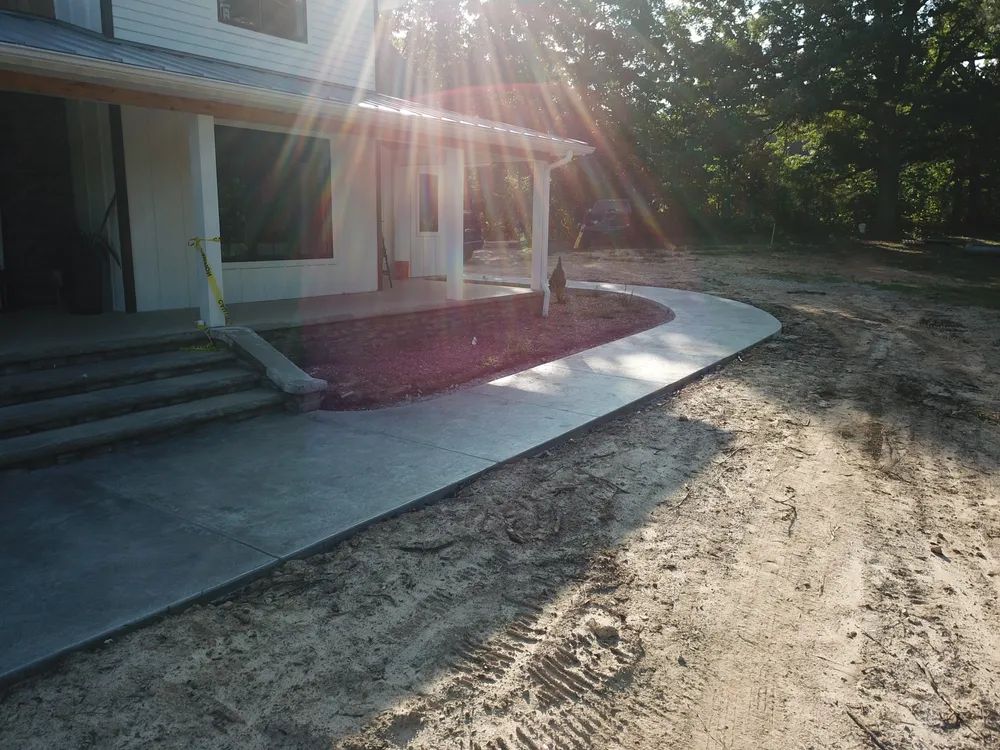 A concrete walkway is being built in front of a house.