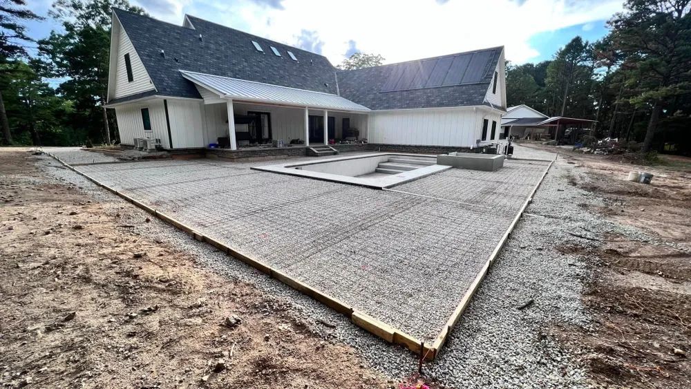 A large white house with a gravel driveway in front of it.