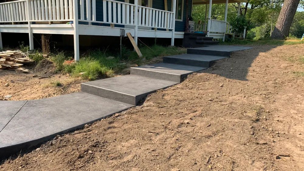 A concrete walkway with steps leading to a house.