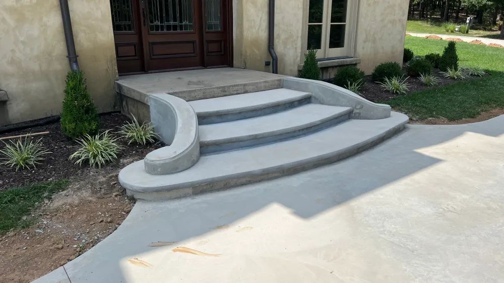 A set of concrete steps leading up to the front door of a house.