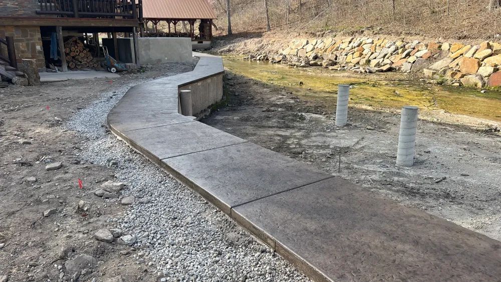 A concrete walkway is being built in front of a house.