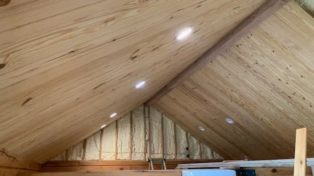 A wooden ceiling in a room with a ladder.
