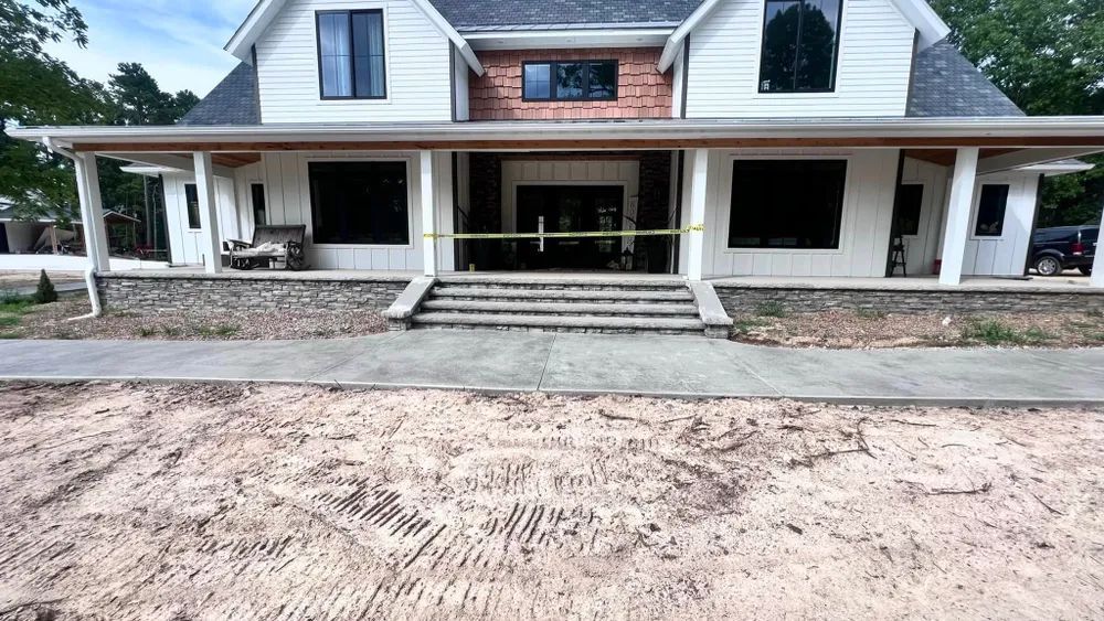 A large white house with a large porch is being built.