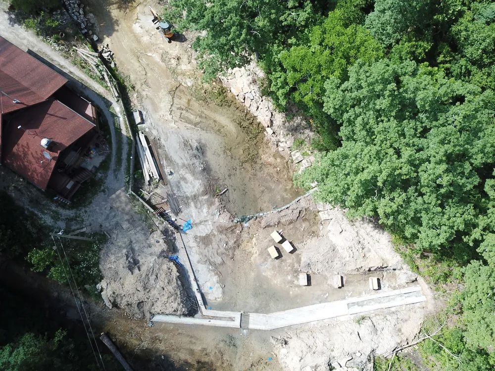 An aerial view of a construction site in the middle of a forest.
