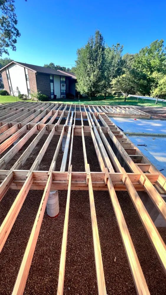 A wooden deck is being built in front of a house.