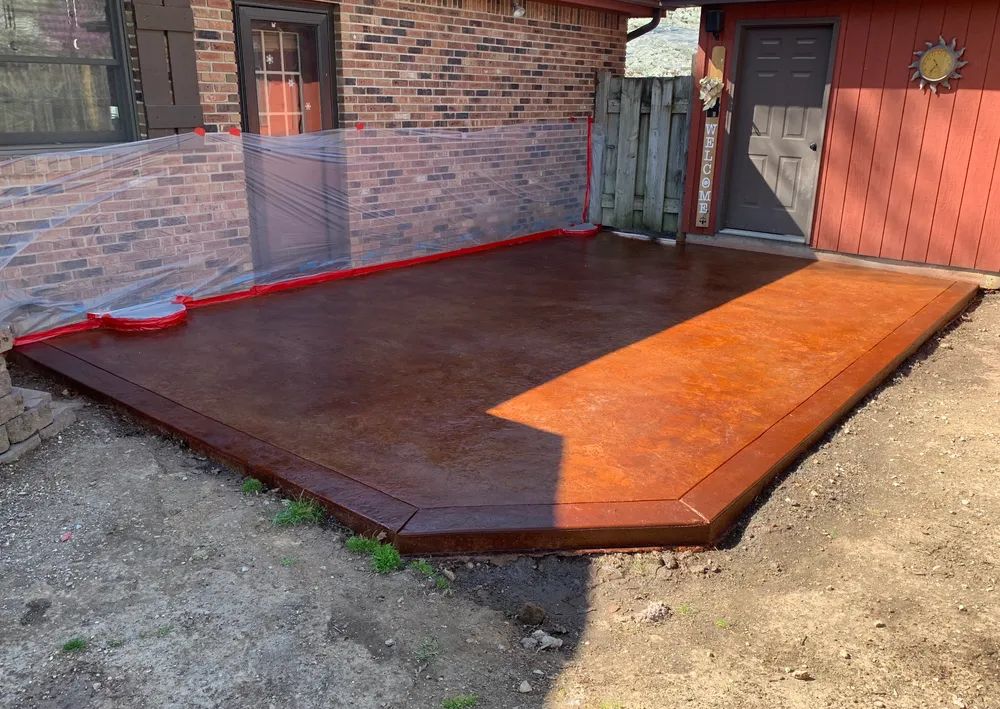 A brick house with a concrete patio in front of it.