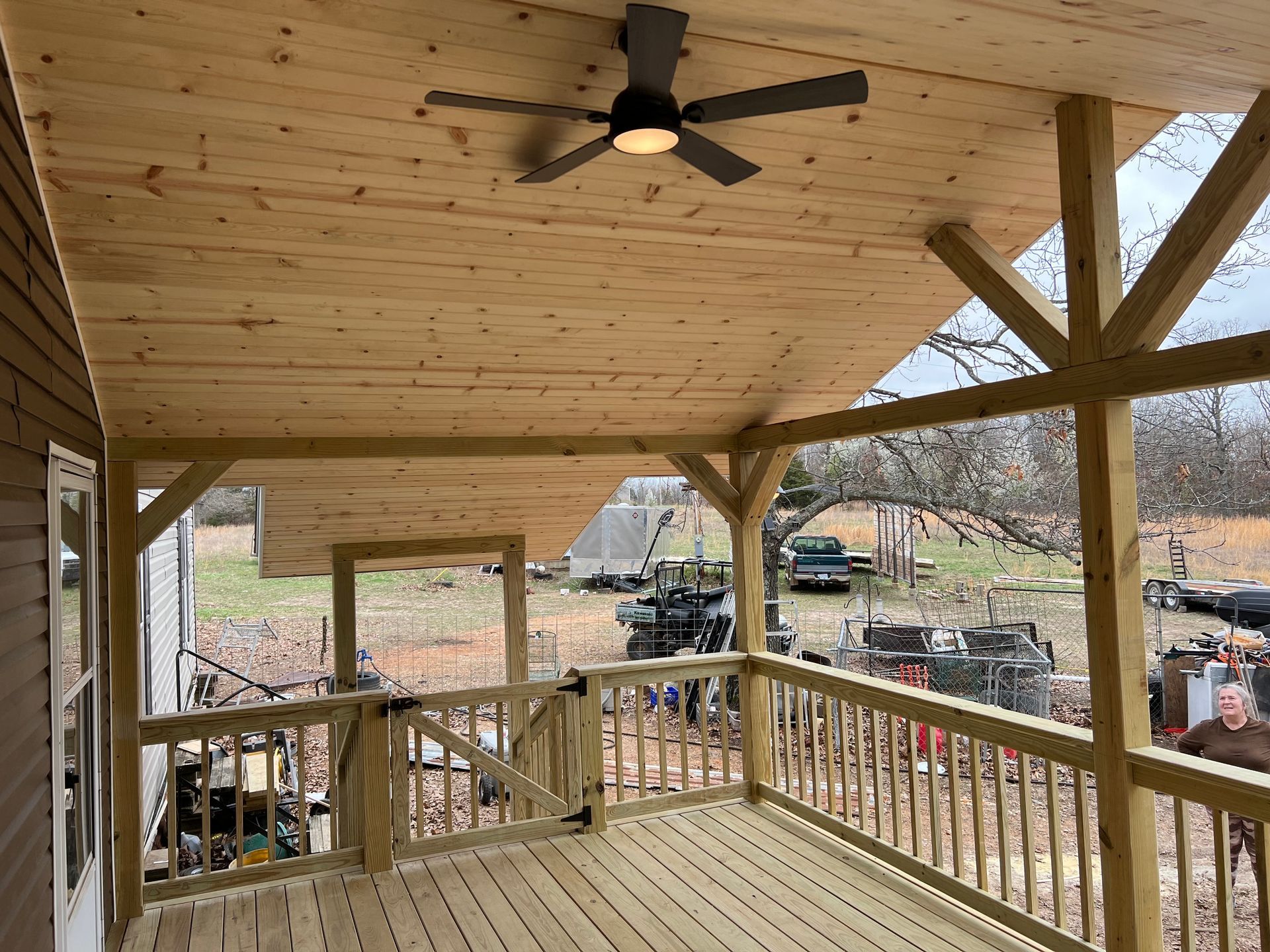 A concrete walkway going through a grassy field with trees in the background