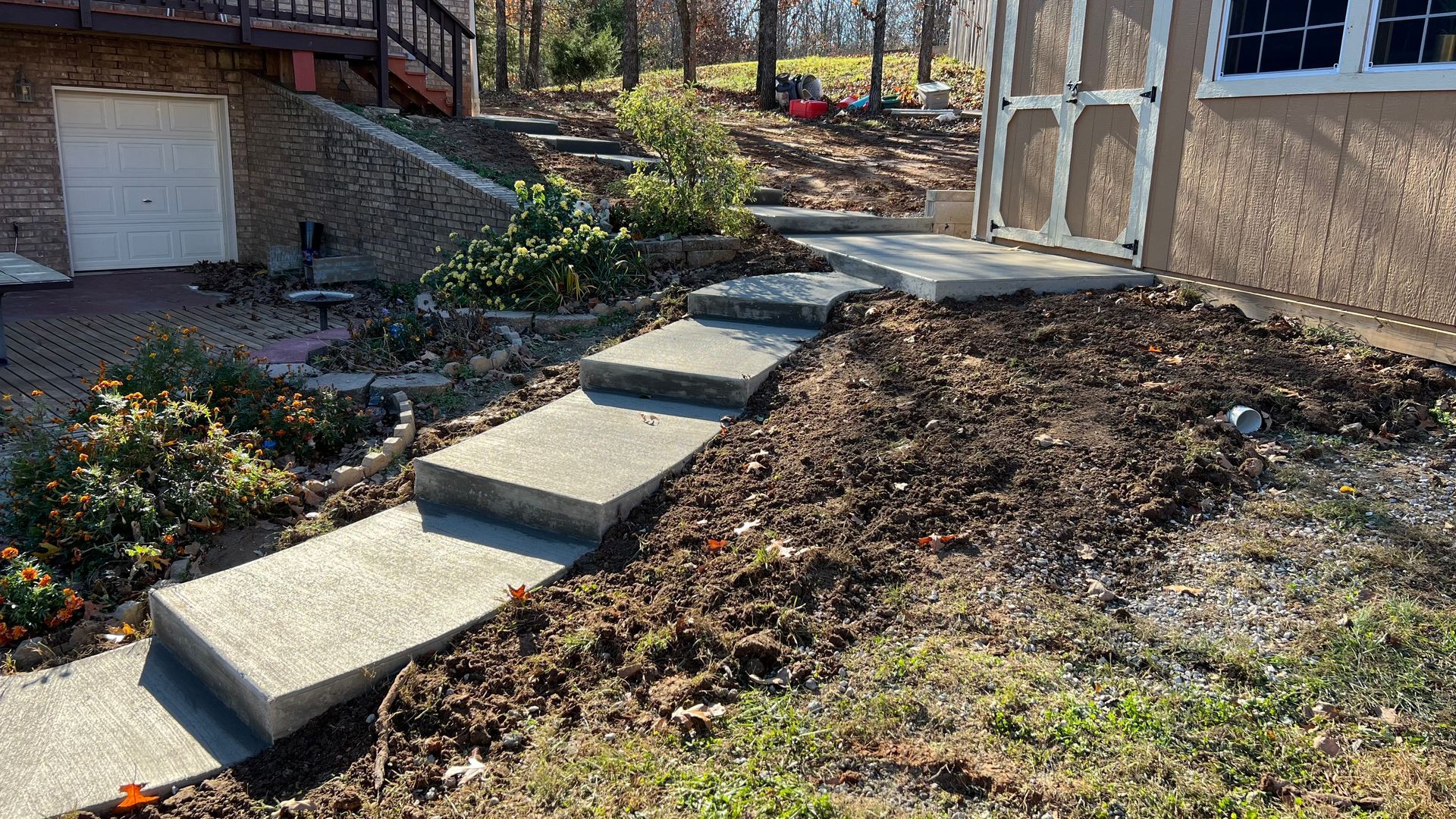 A concrete walkway with steps leading to a house.