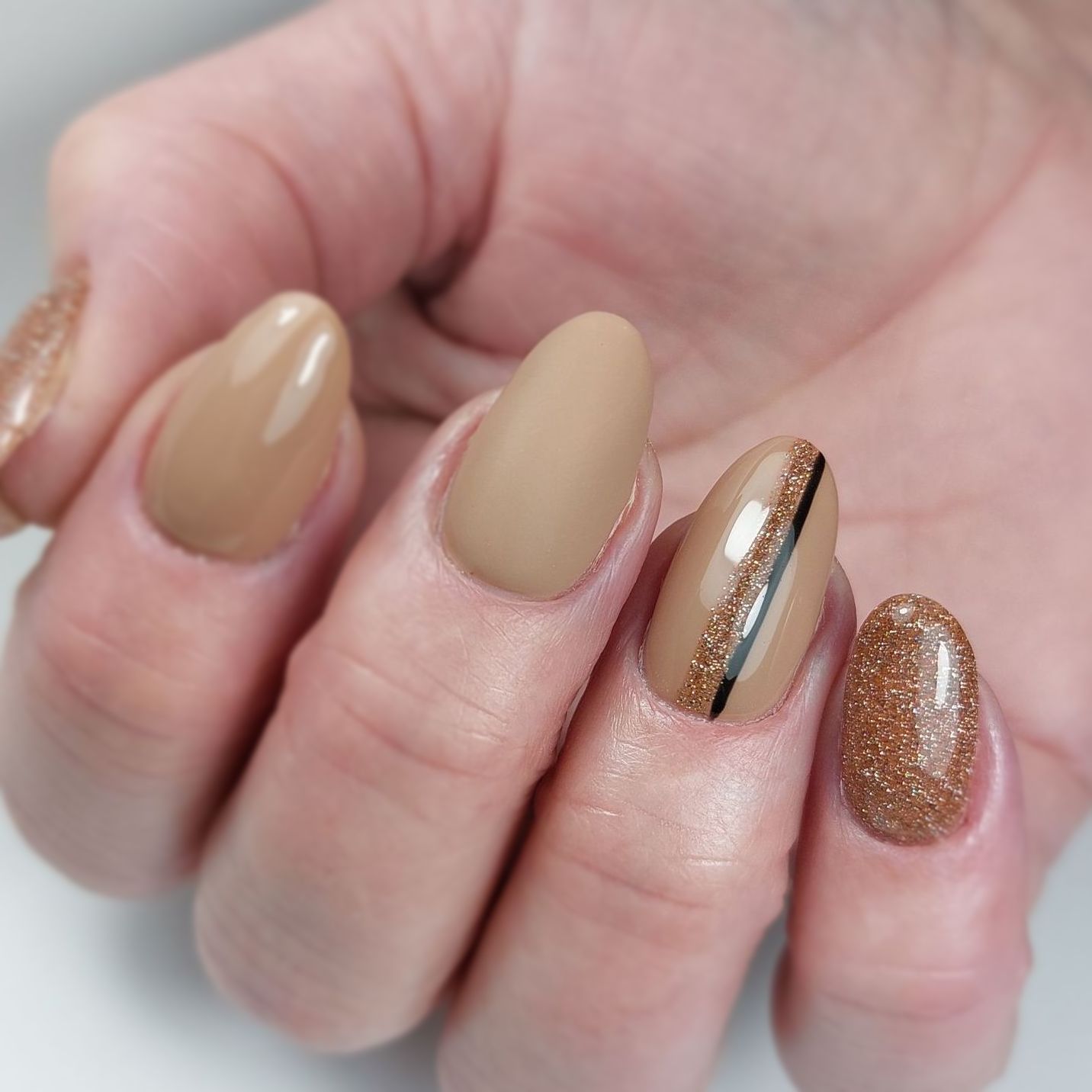 Een close-up van de nagels van een vrouw met een bruin ontwerp