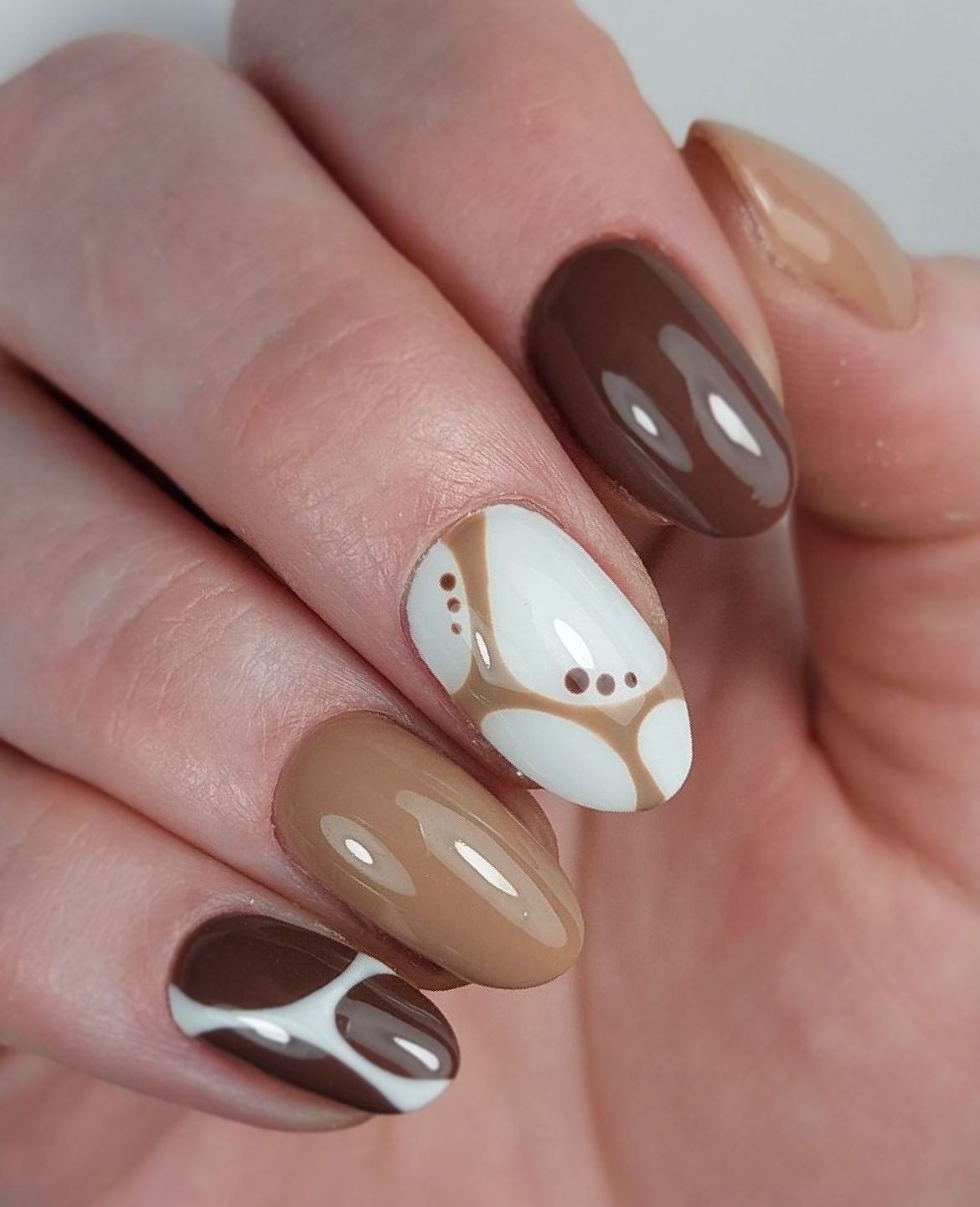 Een close-up van nagels met een trendy bruin en wit ontwerp in nagelstudio Nailservice Rianne in Sint Annaparochie