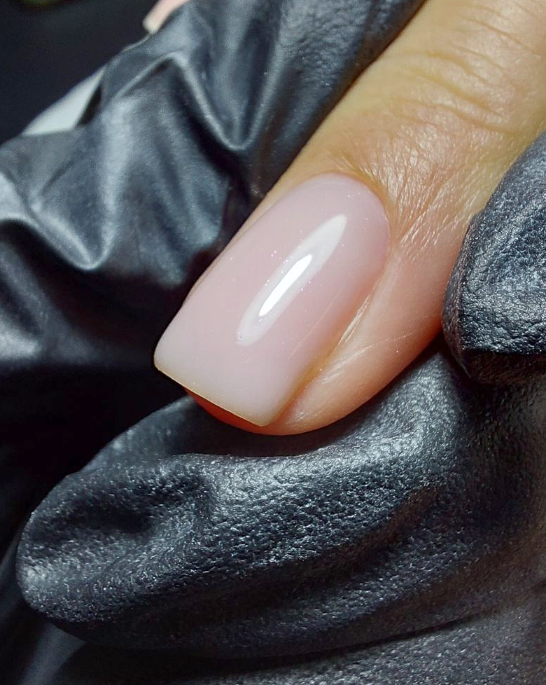 Close-up van een nagel waarbij zorgvuldig een veilige manicure wordt uitgevoerd.