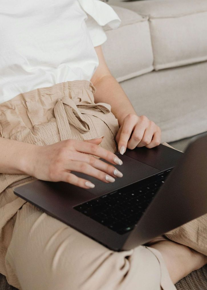 Een vrouw typt op een laptop.