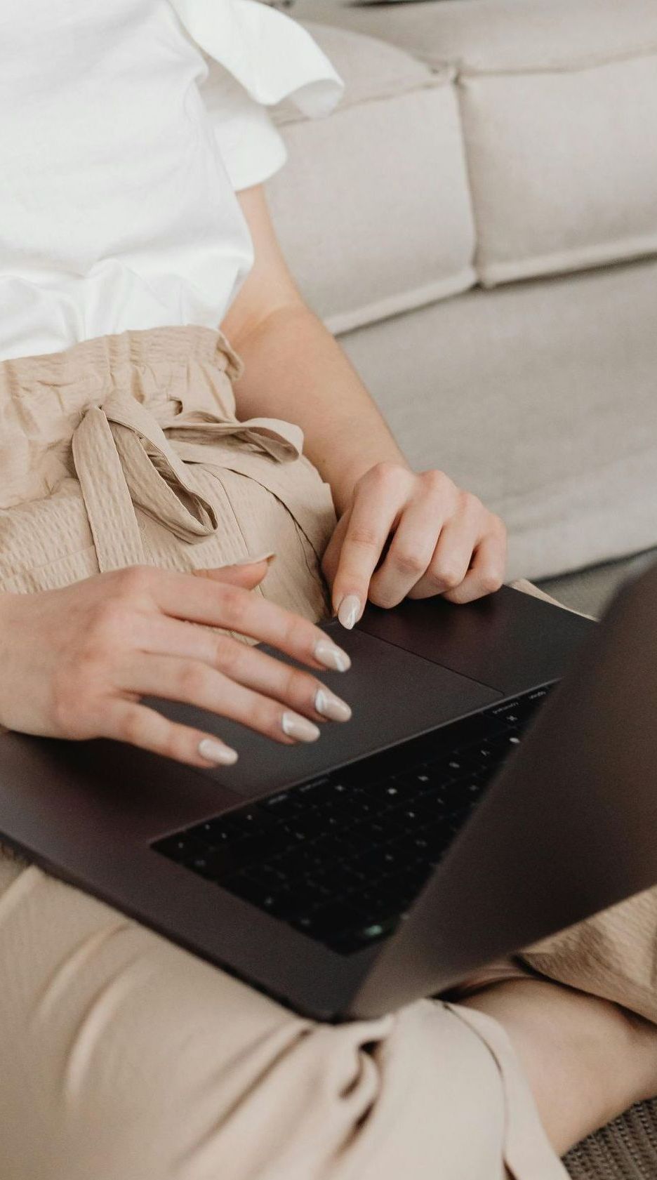 Een vrouw typt op een laptop.