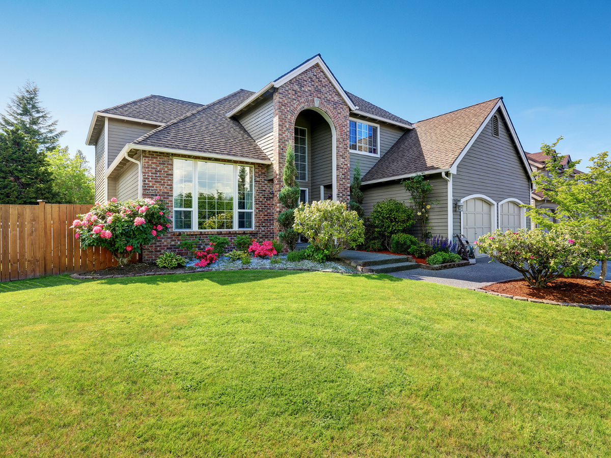 A large house with a lush green lawn in front of it.