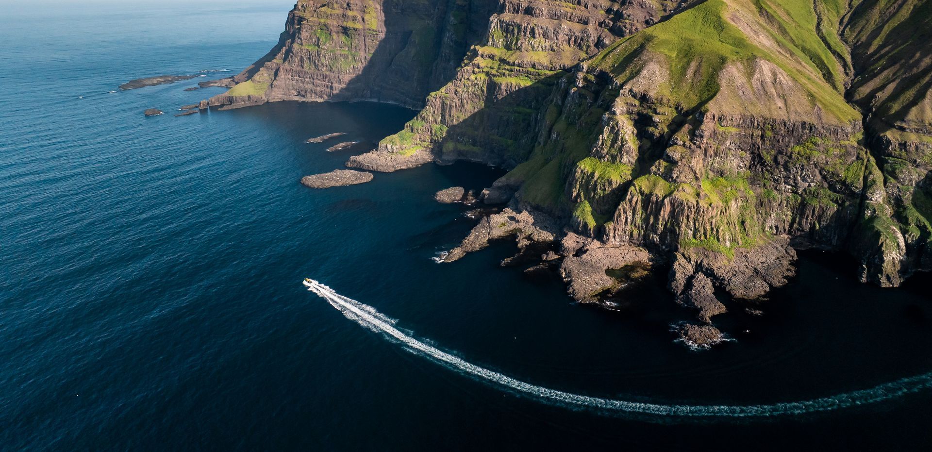 The Puffin Adventures vessel navigating the remote sea cliffs of the Eastfjords.