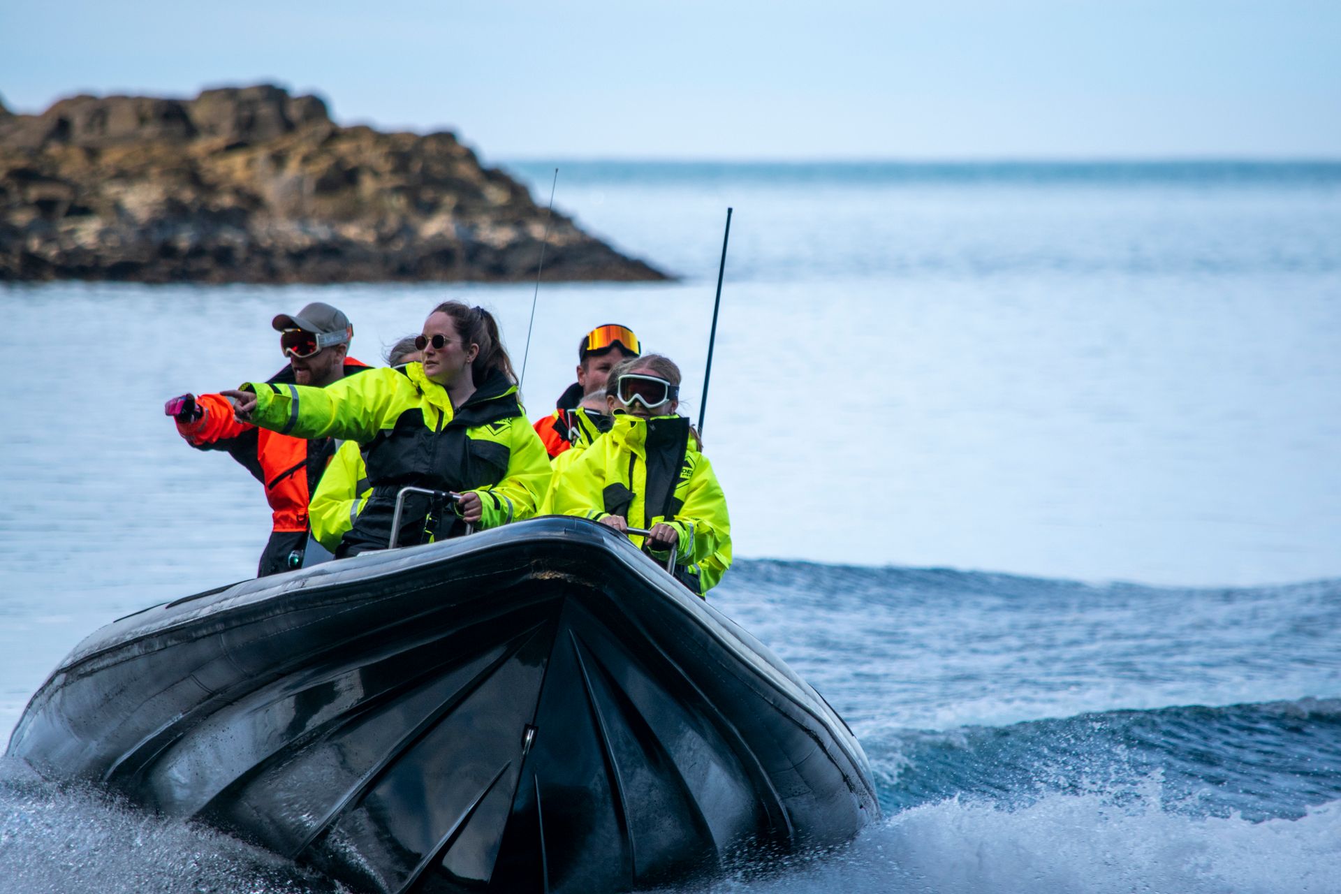Group of people on a RIB boat exploring the stunning coastline of East Iceland.