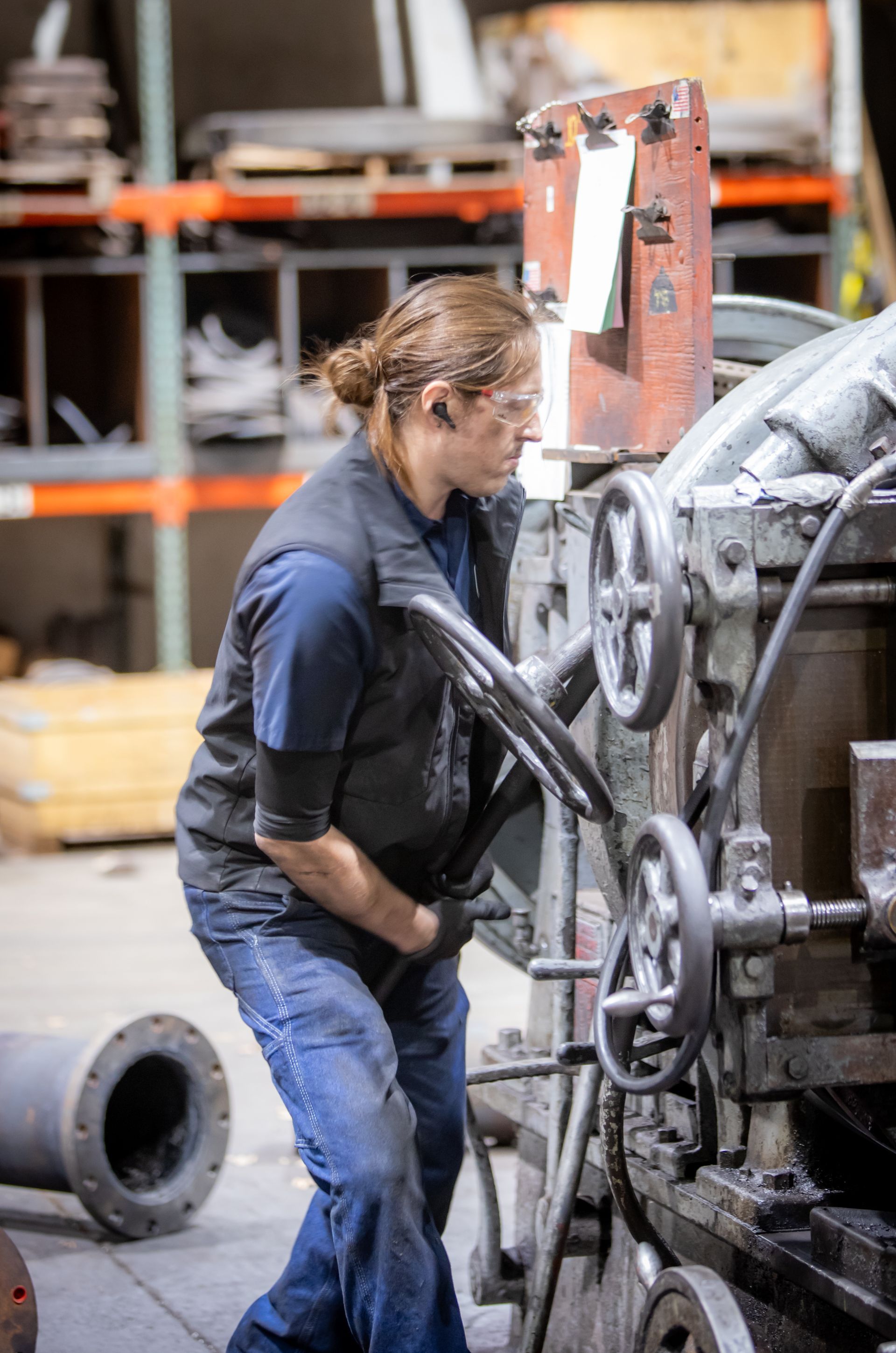 A woman is working on a machine in a factory