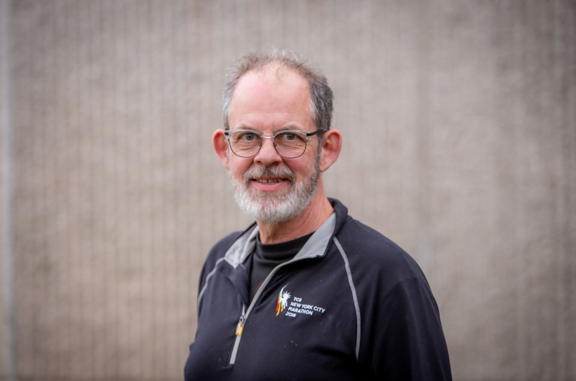 A man with a beard wearing glasses and a black shirt