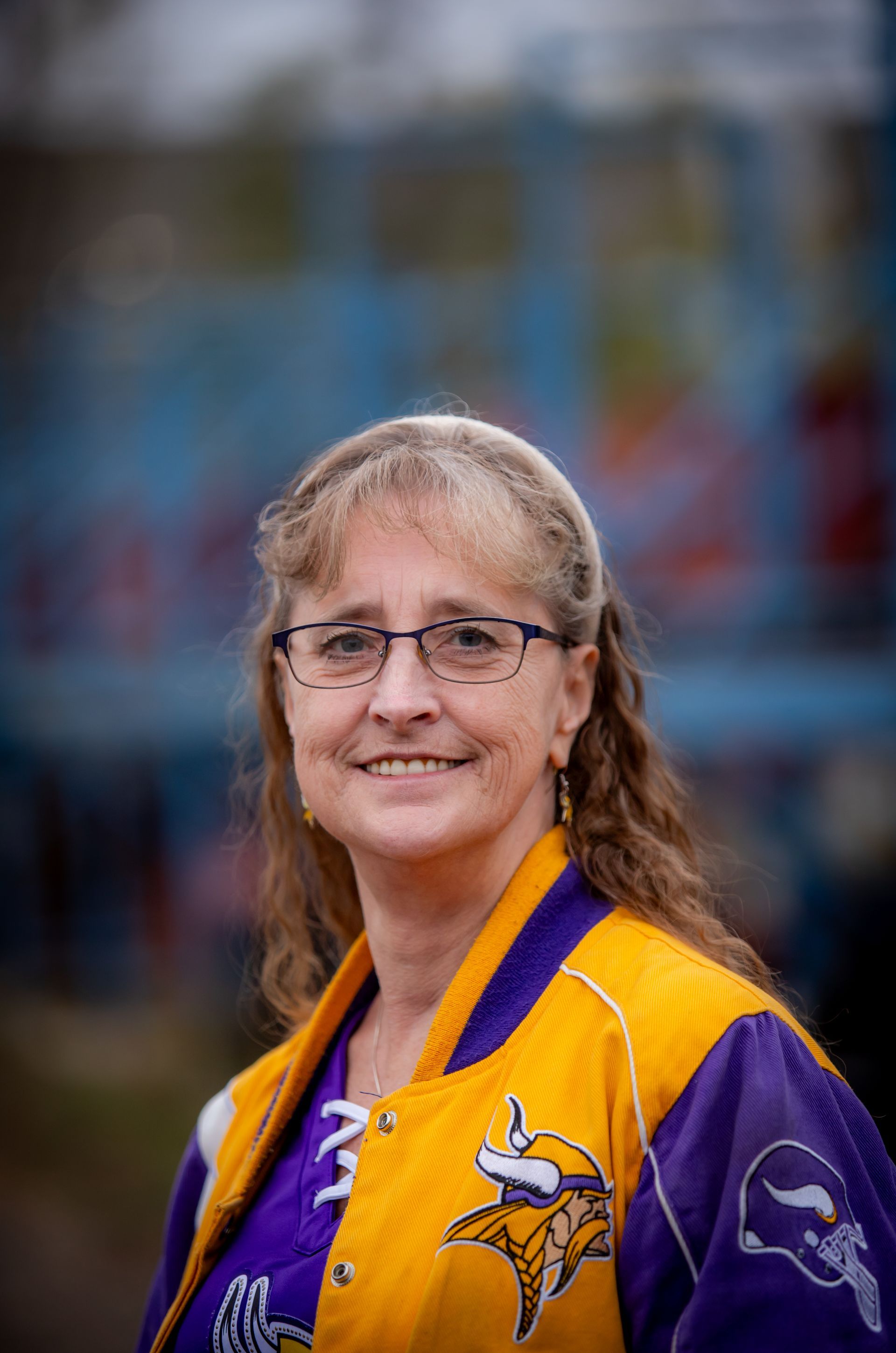 A woman wearing a yellow and purple vikings jacket