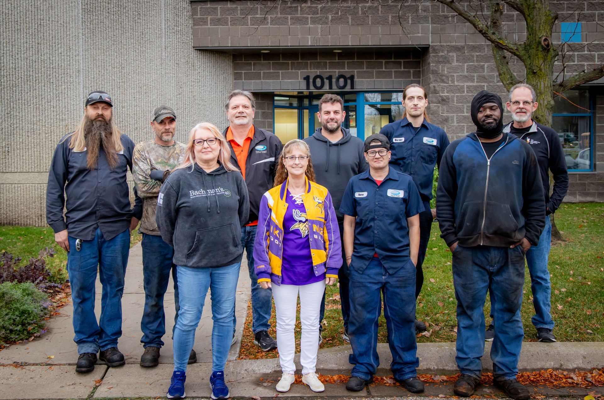 A group of people standing in front of a building with the number 10101 on it