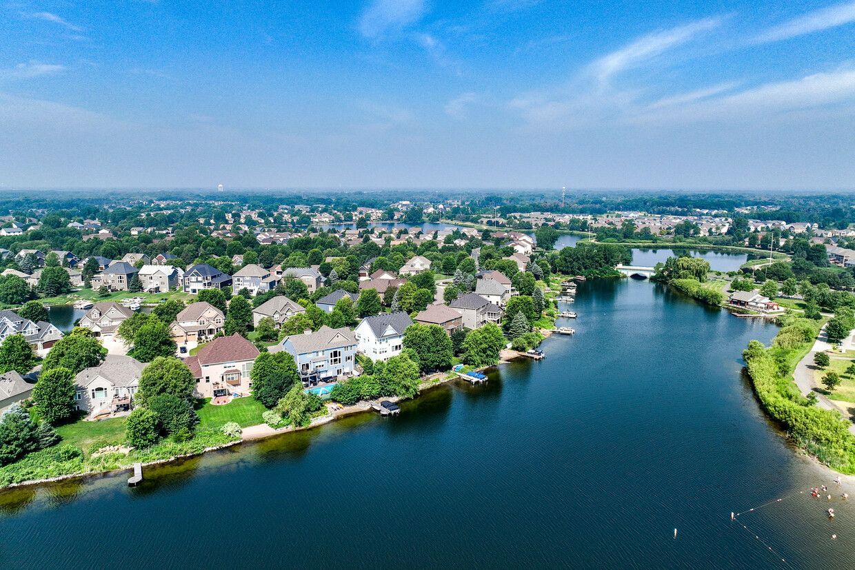 An aerial view of a lake surrounded by houses and trees